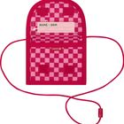 Text: "NAME. NOM." Darunter ein rotes kariertes Muster und ein Band.