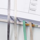 Texte „Fach“ und „Klasse“ auf einer Tabelle, bunte Bänder ragen aus einem aufgeschlagenen Buch.