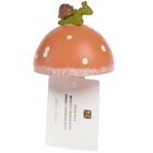 Etikett: "HOLZ-PILZ, WOODEN MUSHROOM". Auf einem Holzpilz sitzt eine kleine Schnecke.