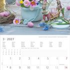 März 2027 Kalender mit Blumenvase und Osterhasen-Deko. Bunte Blumen und blühende Zweige in einem Gießkännchen.