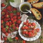 Text "Juni" in roter Schrift. Erdbeeren, Brot, Mozzarella und Kräuter auf Holzplatte arrangiert.