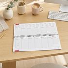 Kalender mit Monatsübersicht Januar 2027 liegt auf einem Schreibtisch. Daneben Kaffee, Stifte und Tastatur.