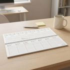 Kalender mit den Daten 4. bis 10. Januar, Montag bis Sonntag. Auf einem Schreibtisch mit Tasse, Stift und Notizzettel.