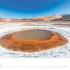 Kalender für Februar 2021. Karge Landschaft mit kleinem, rötlich umrandetem Teich und braunen Hügeln unter klarem Himmel.