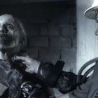 Es gibt keinen sichtbaren Text. Eine grobschlächtige, zombieartige Figur wird von einer gepanzerten Person an der Kehle gehalten.