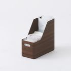 Ein Holzbehälter mit Handtüchern und einer Tüte, die oben hervorragt. Darin steht "Screen" und eine Webadresse.