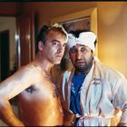 Zwei Männer mit besorgten Ausdrücken. Einer trägt einen Bademantel mit der Aufschrift "Meine Maja". Beide haben Schaum auf dem Kopf.