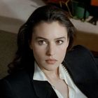 Ich weiß nicht, wer die Frau ist. Sie hat langes, braunes Haar und trägt ein weißes Hemd und einen schwarzen Blazer.