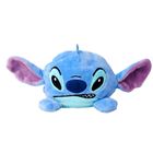 Eine blaue Plüschfigur mit großen Ohren und einem frechen Gesichtsausdruck, breites Lächeln und runde schwarze Augen.