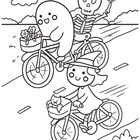 Ein Skelett, ein Geist und eine Hexe fahren auf Fahrrädern. Die Hexe hat eine Katze im Korb, der Geist Blumen.