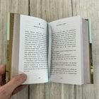 Textseiten aus einem Buch mit den Überschriften "Arthur Machen" und "The Inmost Light". Eine Hand hält das Buch offen.
