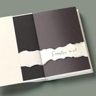 "Freedom to all" steht auf einem eingerissenen Papierstreifen in einem aufgeschlagenen, minimalistischen Buch.