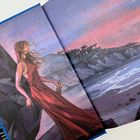 Illustration: Eine Frau in rotem Kleid steht an einer felsigen Küste, der Himmel leuchtet in pink und lila Tönen.