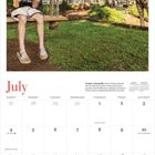 Text: "July. Swingin' with giraffes." Junge auf Schaukel, eine Giraffe neben ihm, Herrenhaus im Hintergrund, blauer Himmel.