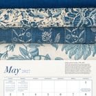 "May 2027" steht oben. Darunter klassische Kalenderanordnung. Stoffe mit blauen Mustern über dem Kalender.