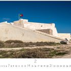 "Fortaleza Sagres" steht unten links. Ein helles Fort mit einer Flagge weht im Wind, umgeben von einer trockenen Landschaft.