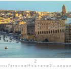 Kalender: "Senglea". Zahl 2 groß. Zeigt eine Stadt mit hellen, alten Gebäuden am Wasser. Boote im Hafen.