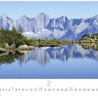 "Spiegelsee" steht unten links. Ein stiller Bergsee spiegelt majestätische Berge und Bäume wider, mit einer klaren, blauen Himmel.