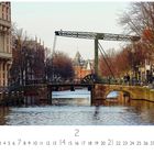 Text "Ziehbrücke". Eine Zugbrücke über einem Kanal mit historischen Gebäuden und Bäumen im Hintergrund.
