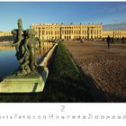 "Schloss Versailles", mit einer Skulptur im Vordergrund, einem großen Gebäude und einem Teich bei Sonnenuntergang.