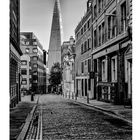 Kalender "The Shard", Monat Februar. Pflasterstraße mit alten Gebäuden, im Hintergrund ein modernes, spitzes Hochhaus.