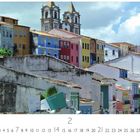 Salvador Da Bahia. Bunte, historische Häuser und zwei Kirchtürme unter einem blauen Himmel. Datumsreihe darunter.