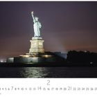 "Statue of Liberty", Monatskalender für Februar. Die leuchtende Freiheitsstatue steht vor einem dunklen Himmel.