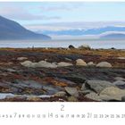 Alaskastrand im Nebel. Kalenderseite für Februar. Küstenlandschaft mit Steinen, Meer, Bergen und leicht nebligem Himmel.
