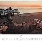 "Rügen" steht oben links. Kalenderblatt für Februar. Steg zum Seebrückenhaus, Sandstrand bei Sonnenaufgang.