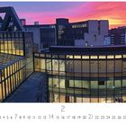 Landtag, Februar-Kalender. Moderne Gebäude mit Glasfassaden bei Sonnenuntergang und einem farbenfrohen Himmel.