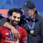 Zwei Männer mit Medaillen lächeln stolz. Einer trägt eine LFC-Kappe, beide tragen Sportkleidung.