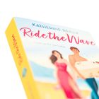 Text: „KATHERINE REILLY“, „Ride the Wave“, „Lese-erlebnis für die Liebe“. Illustration: Ein Paar am Strand.