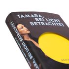 "Tamara, bei Licht betrachtet" steht oben. Buchcover: Frau schaut zur Seite, gelber Kreis auf dunklem Hintergrund.