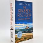„Die Krabbenfischerin: Das Erbe der Küste“ von Danela Pietrek. Eine Küstenszene mit einem Fischkutter.