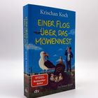 „Einer flog über das Möwennest“ von Krischan Koch. Illustration: Möwenfamilie und Mann in Uniform auf Wiese.