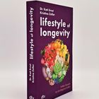 Buch mit lila Umschlag. Titel: "lifestyle of longevity". Autoren: Dr. Kati Ernst, Kristine Zeller. Buntes Obstgemälde.