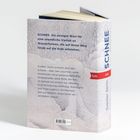 Text: "SCHNEE. Ein einziges Wort für eine unendliche Vielfalt an Wasserformen..." Graue, strukturierte Buchrückseite.