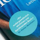 „Ein außergewöhnlich ehrliches und berührendes Buch.“ Dr. Müller-Wohlfahrt. Blaues rundes Zitatfeld auf blauem Hintergrund.