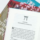 "STATION NISHINOMIYA-KITAGUCHI" ist der Titel über einem Bild eines traditionellen Torii. Darunter ein Buchtext.