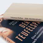 Zwei Bücher mit dem Titel "Der Teufelspakt" von Sebastian Haffner, eines in hellerem Einband auf einem dunkleren liegend.