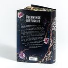 Text: "ÜBERWINDE DIE FURCHT". Ein Buch mit floralen Illustrationen und Text über Königreiche, Monster und Mut.