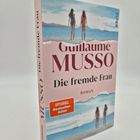 "Guillaume Musso, Die fremde Frau, Roman. SPIEGEL Bestseller-Autor." Zwei Frauen am Strand, Segelboot im Hintergrund.