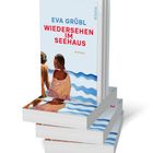 Stapel von Büchern mit dem Titel "Wiedersehen im Seehaus" von Eva Grübl. Cover zeigt zwei Frauen am Wasser.