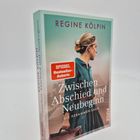 „Zwischen Abschied und Neubeginn“, Buch von Regine Kölpin, zeigt Frau mit hochgestecktem Haar und Koffer.