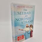 Buchcover von "Das Seebad am Nordseestrand" von Regine Kölpin, zeigt zwei Frauen am Strand, "SPIEGEL Bestseller Autorin" Zeichen.