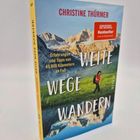 Buchtitel: "WEITE WEGE WANDERN". Autor: Christine Thürmer. "SPIEGEL Bestseller". Vor Bergen wandert eine Person.