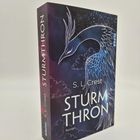Buchtitel "STURMTHRON" von S. L. Crest, ein Roman. Cover zeigt eine stilisierte Illustration eines majestätischen Vogels.