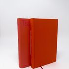 Zwei orange Bücher, auf den Rücken steht: "Tschikago, Alexandra Scast, CLAASSEN". Eines ist geöffnet mit einem Lesezeichen.