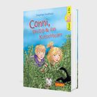 Cover von "Conni, Phillip & das Katzenteam" von Dagmar Hoßfeld. Conni und Phillip schauen aus Sträuchern, mit Katzen.