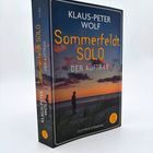 „Klaus-Peter Wolf: Sommerfeldt Solo – Der Auftrag“. Ein Mann vor einem Sonnenuntergang am Meer, Ostfriesenkrimi.